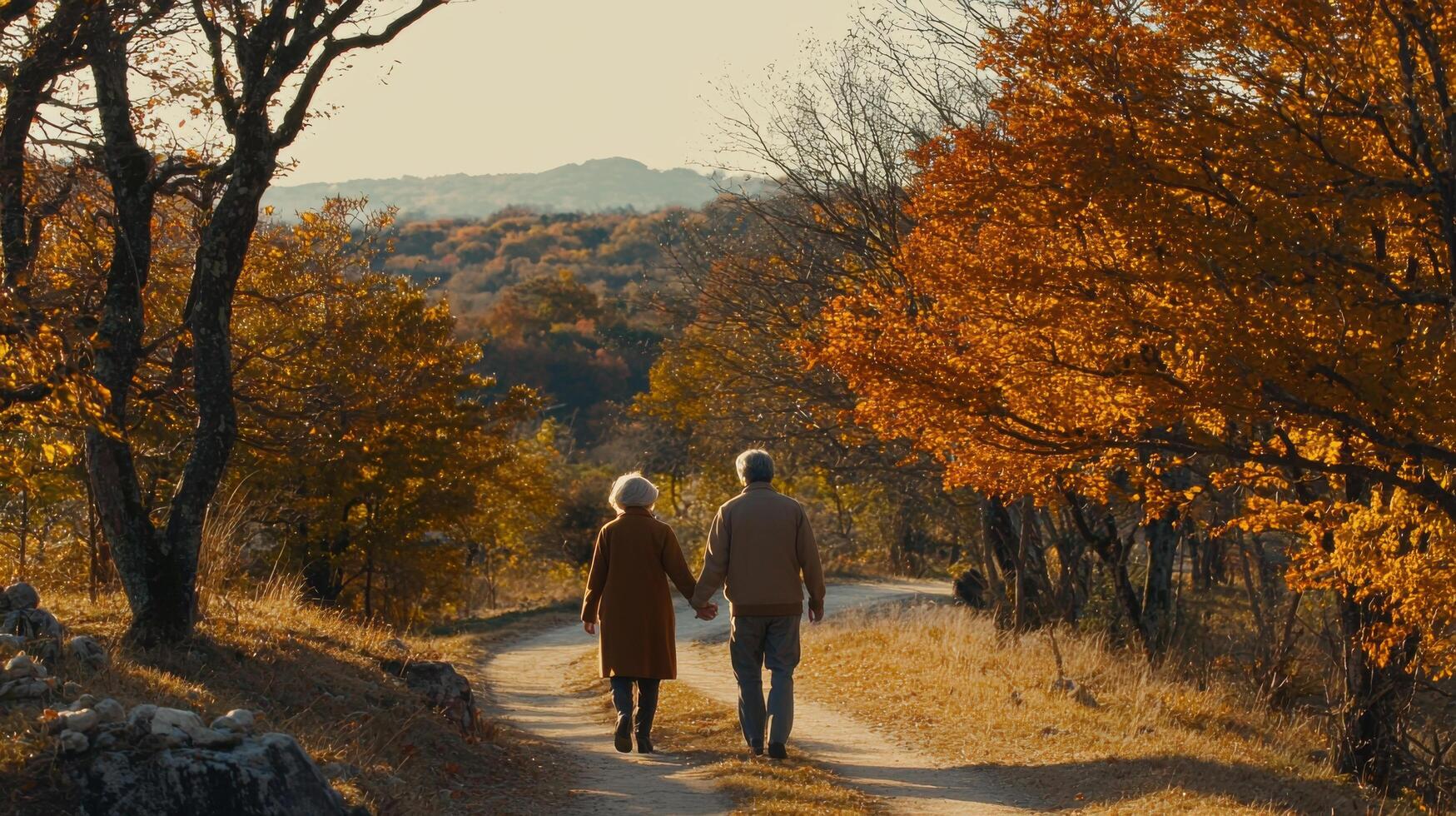couple walks hand in hand along scenic autumn path surrounded by trees photo