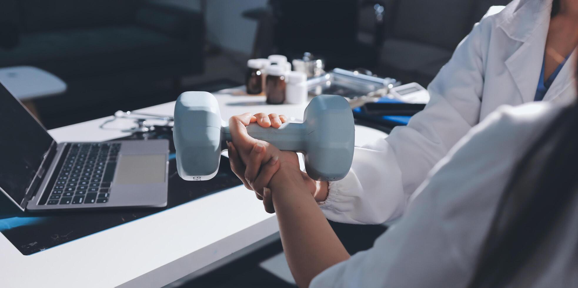 A woman is holding a dumbbell in front of a laptop photo