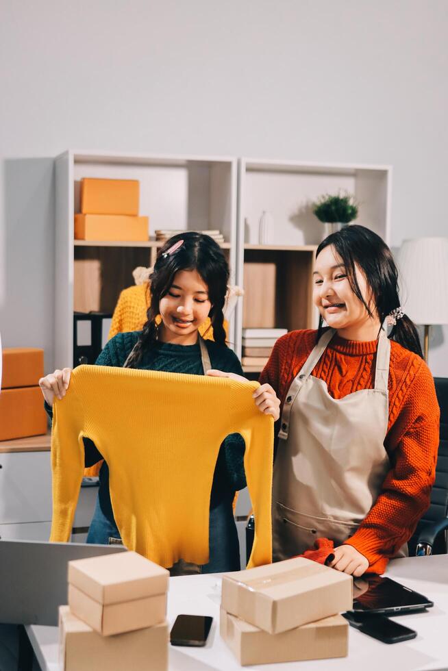 Two women in an office holding up a shirt photo