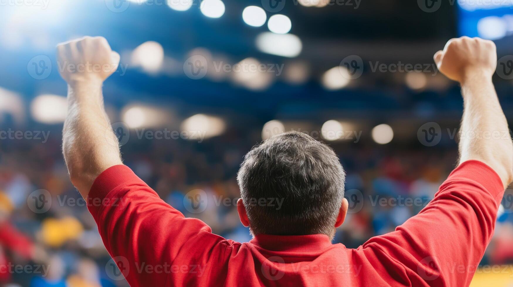 A passionate supporter raises arms in excitement, cheering for their team during a thrilling sports event in a vibrant arena filled with fans, capturing the joy of victory photo