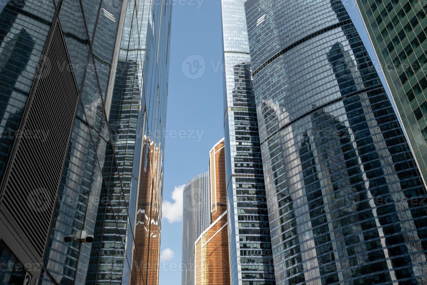 Modern Skyscrapers Reflect Blue Sky and Clouds in Moscow, Showcasing Urban Architecture and Design Amid Urban Development photo
