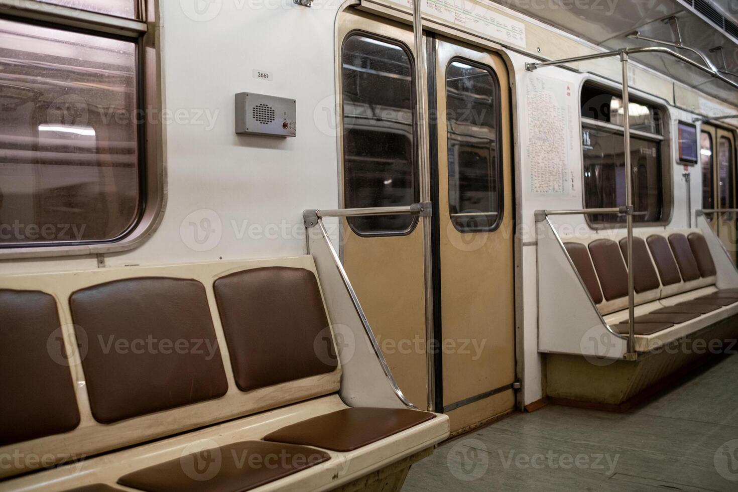 Empty Subway Train Interior Highlighting Brown Seating and Metal Railings During Off-Peak Hours photo