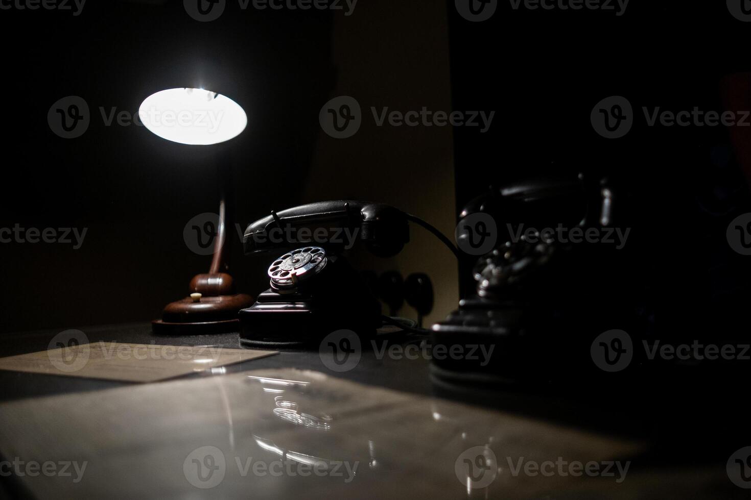 Old-fashioned Telephones and a Lamp Create a Nostalgic Atmosphere in a Dimly Lit Room, Showcasing Vintage Communication Tools photo
