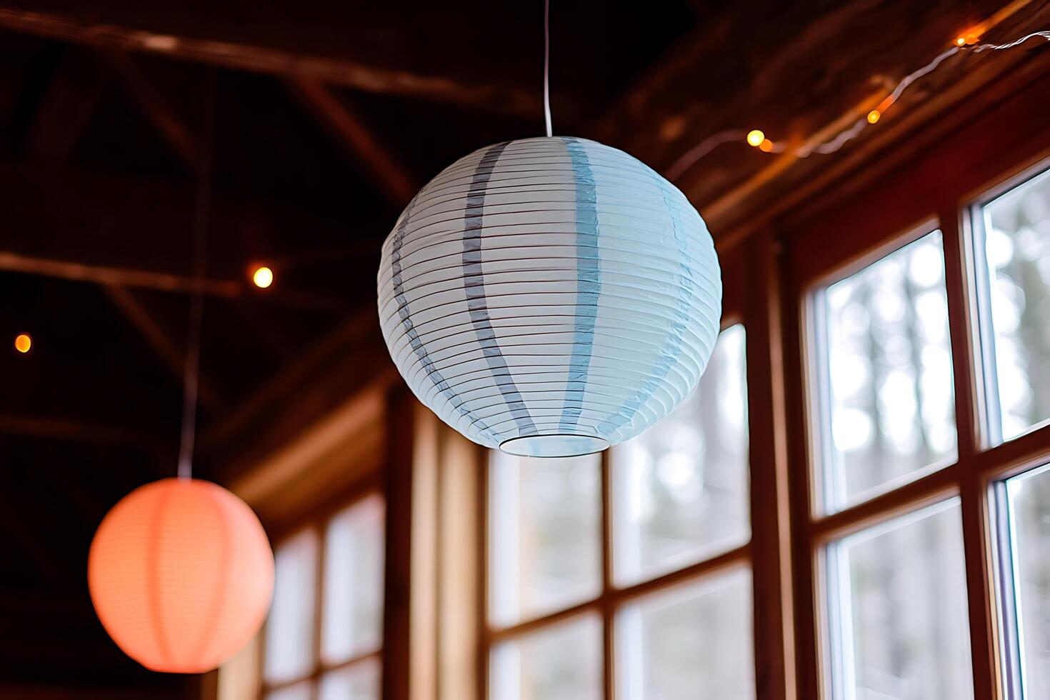 Hanging Paper Lanterns Illuminate a Rustic Cabin Interior. A soft, ambient light fills the space, creating a peaceful and inviting atmosphere. photo