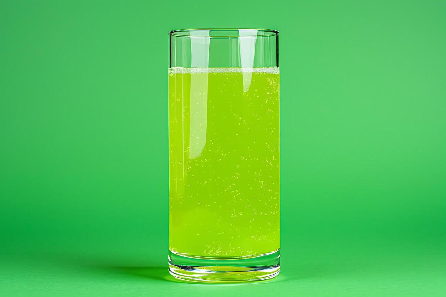 Tall Glass of Sparkling Green Liquid Against a Green Background. A refreshing image perfect for drink advertisements or health-related content. photo