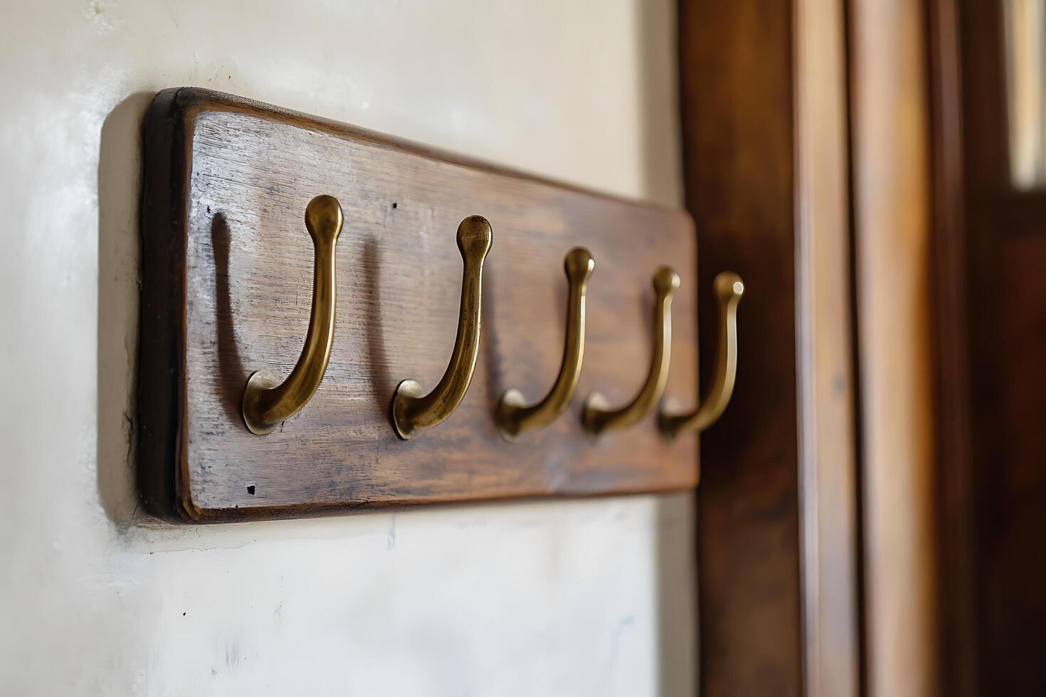 Antique Brass Hooks on Wooden Wall Mount Interior Design Detail. photo