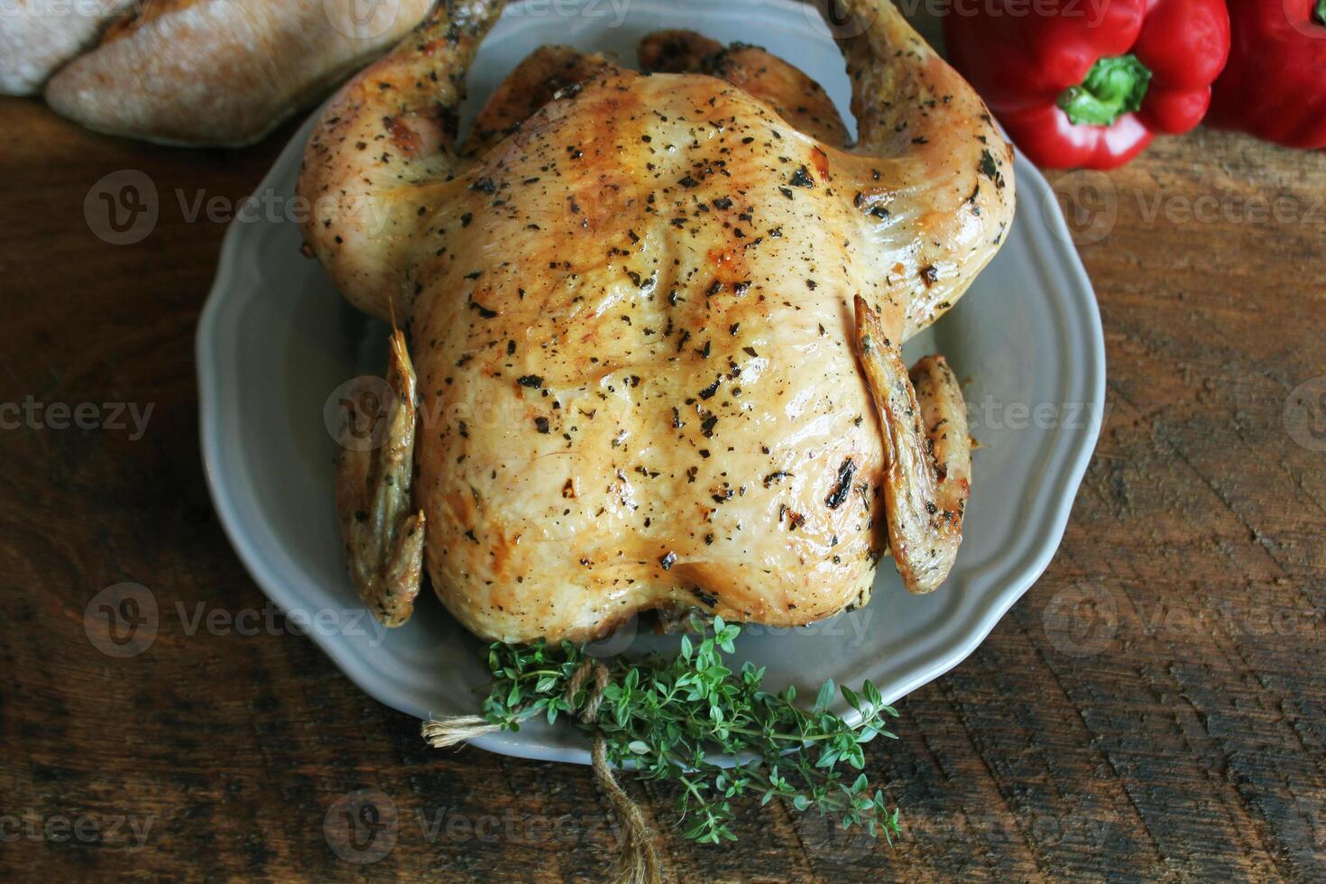 Roasted or baked whole chicken , homemade for a family dinner on a brown table. Top view with copy space. photo