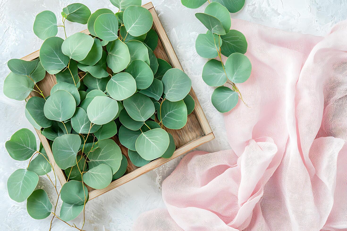 Eucalyptus Leaves in Wooden Tray with Pink Fabric Drape Elegant Flat Lay Photography. photo