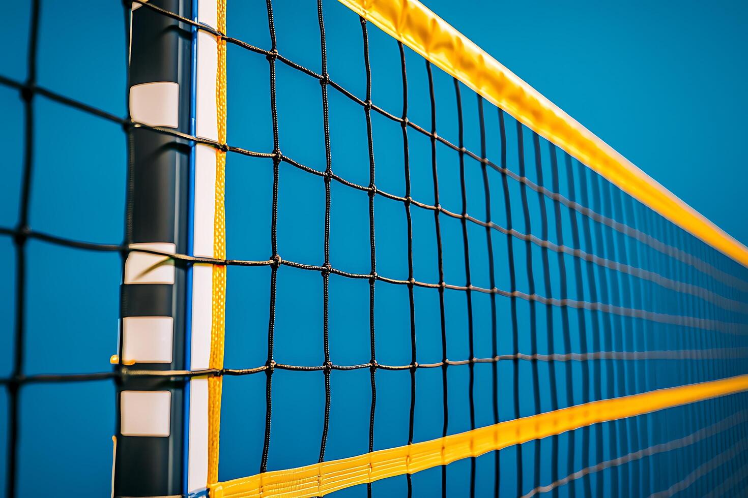 Close-up of a Volleyball Net Against a Vibrant Blue Sky. The image showcases the intricate details and bright colors of the sports equipment. photo