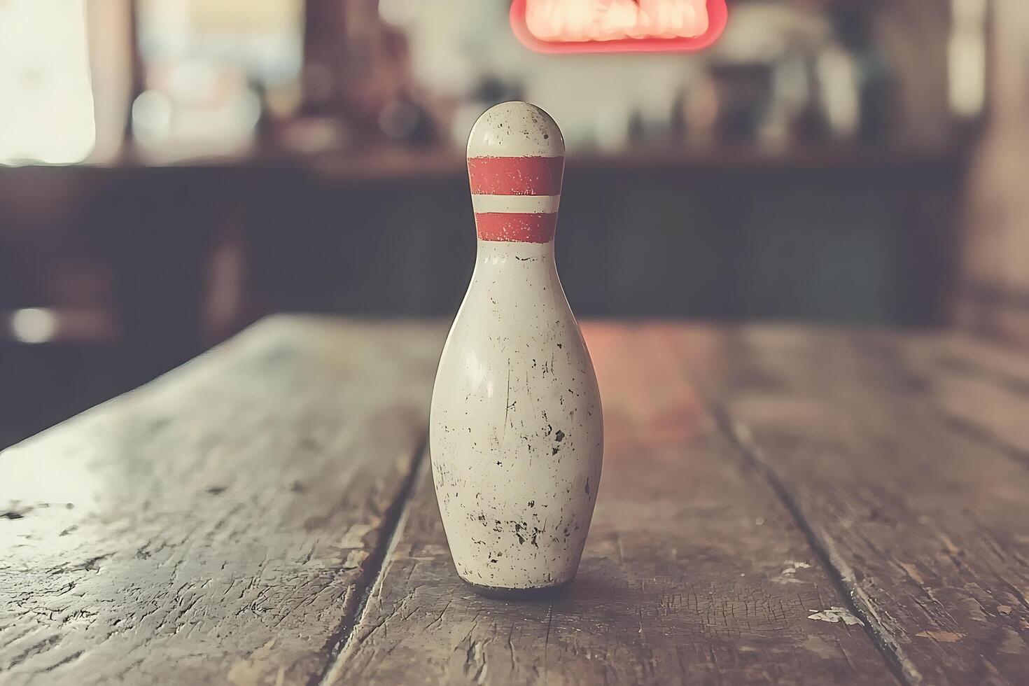 A Single, Weathered Bowling Pin on a Rustic Wooden Table. photo