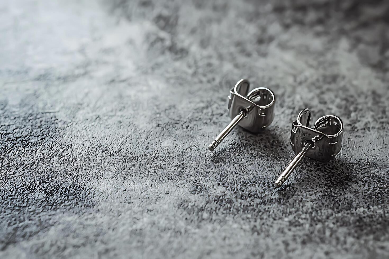 Elegant Silver Stud Earrings on a Textured Surface. A close-up shot showcasing the detail of stylish jewelry. photo