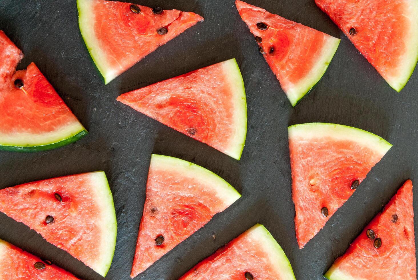 Watermelon slices on a black surface photo