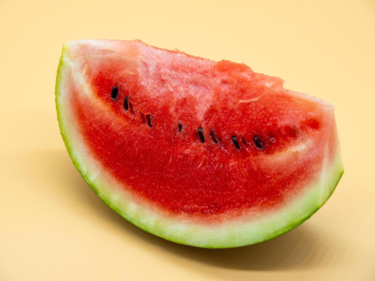 A slice of watermelon on a yellow background photo