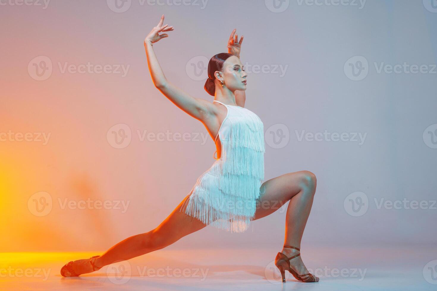 Latin Female Dancer in White Fringe Dress Performing Dynamic Latin Dance Pose in Studio photo