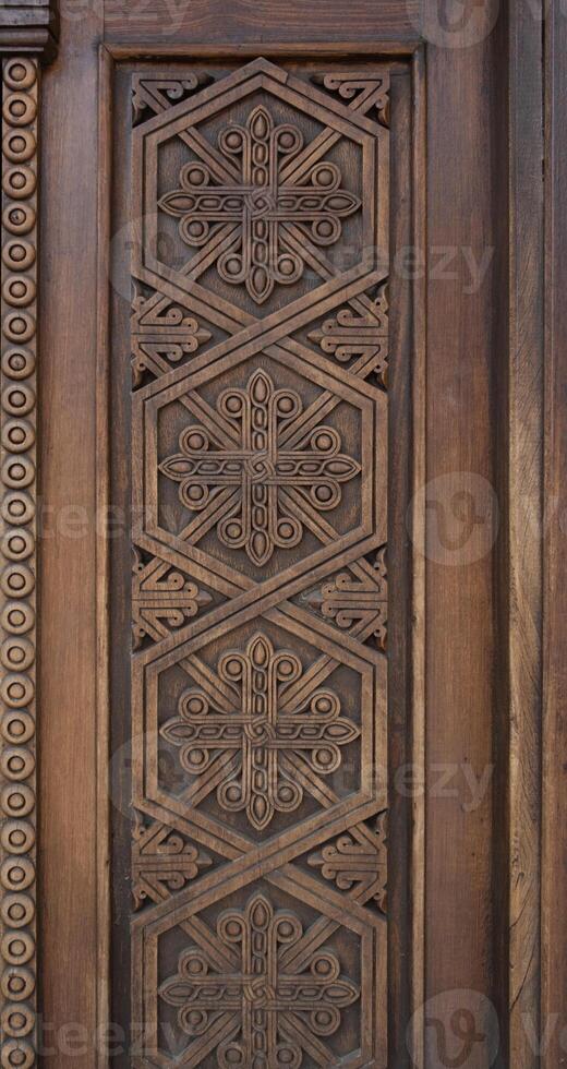 Wooden door with carved pattern in ancient temple, Geghard, Armenia photo