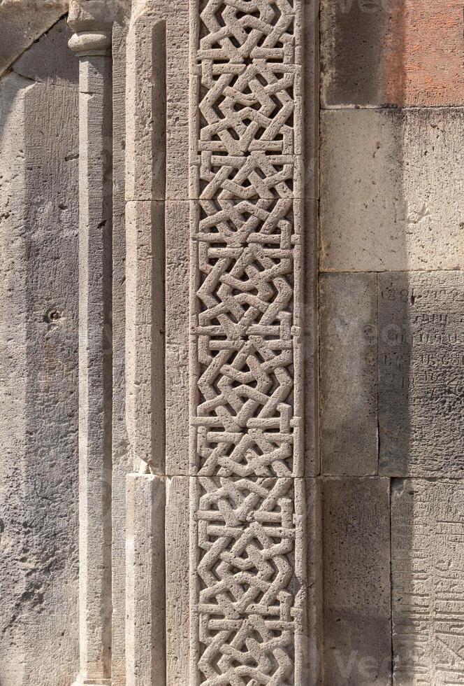 Pattern carved into the stone wall of an ancient temple, Gerhard, Armenia photo