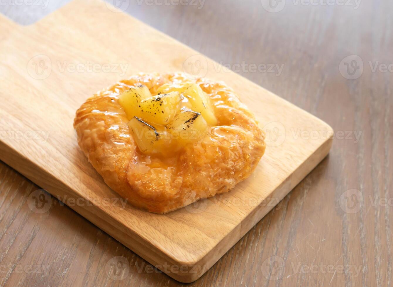 Golden Pineapple Danish Pastry on Wooden Board side view of Flaky Tropical Treat photo