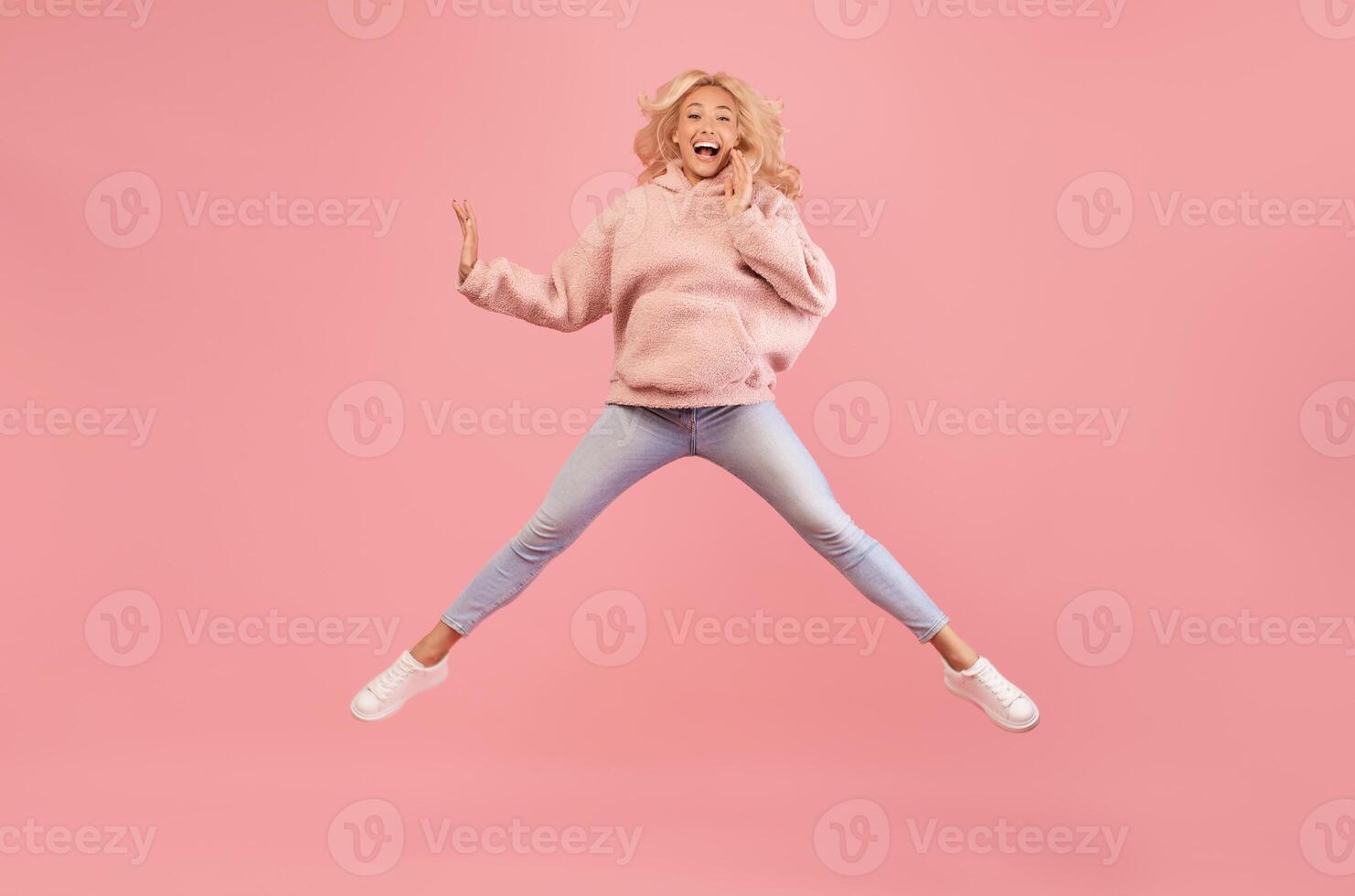 Wow offer. Full length portrait of surprised lady jumping, staring at camera, shocked by news or offer, isolated on pink studio background, free space photo