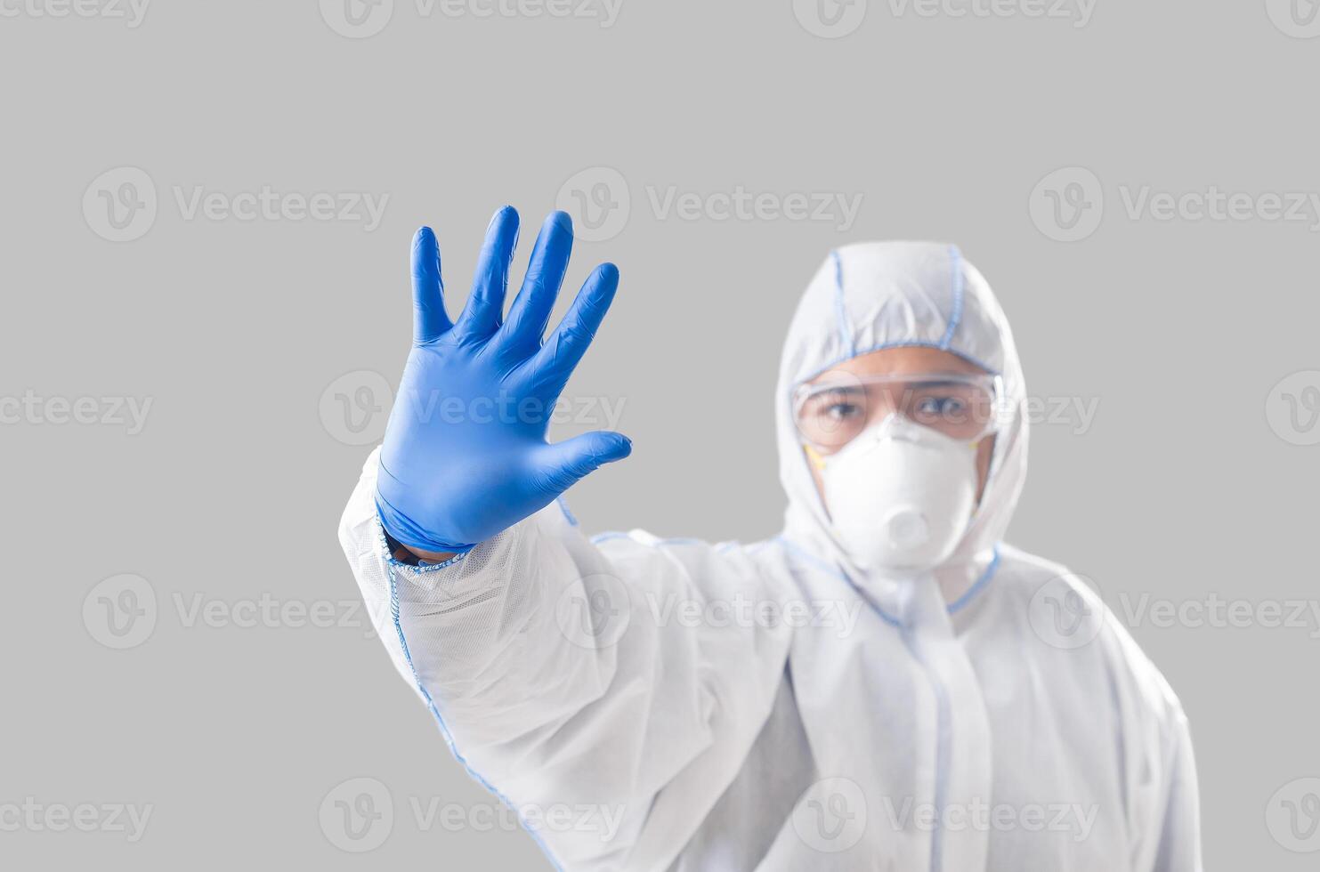 Virus outbreak concept. Asian man in protective suit makes stop sign with hand photo