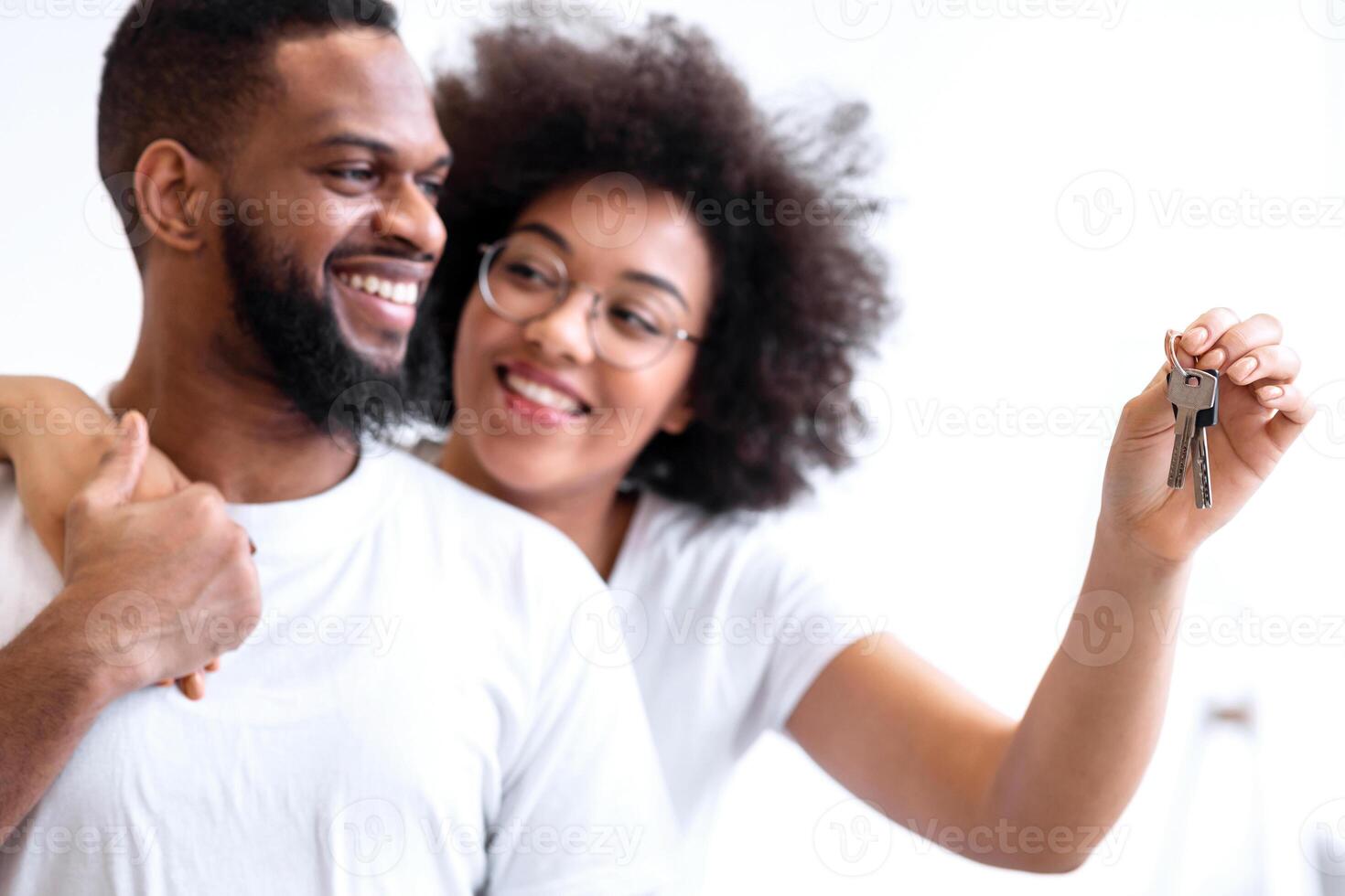 Family Housing. Happy Black Spouses Holding New House Key Embracing Standing At Home. Selective Focus On Keys, Shallow Depth. Real Estate, Property Ownership And Mortgage photo
