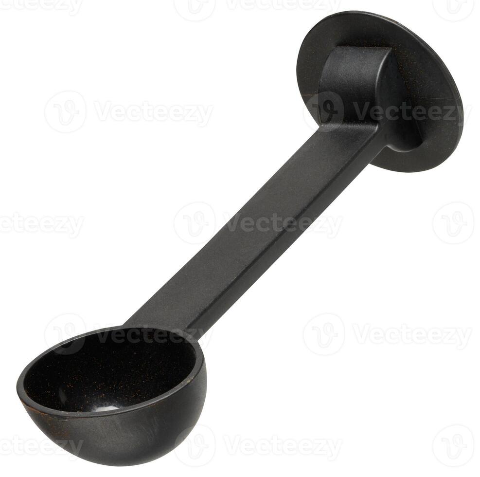 Black plastic measuring spoon for ground coffee, designed for coffee machine, with long handle and round base, isolated on background. photo