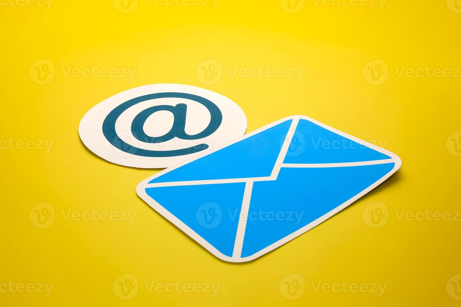 Paper letter and at sign on yellow background, with copy space. Business concepts of online contact channels, and electronic mail inbox notifications. photo