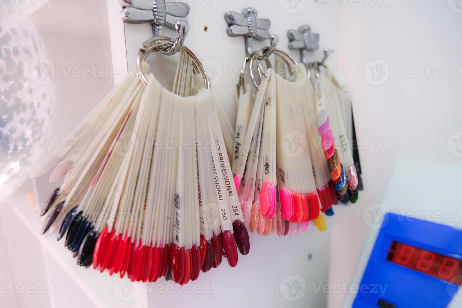 A row of nail polish bottles are hanging on a wall photo
