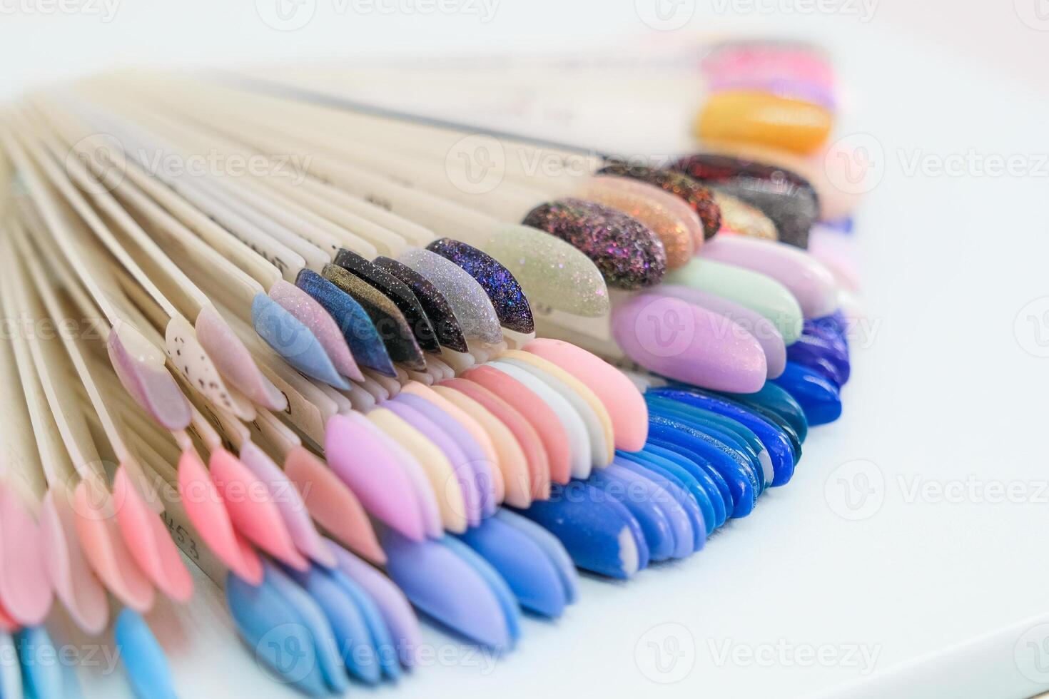 A row of nail polish bottles with a variety of colors photo
