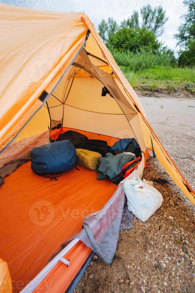Within the spacious confines of the large tent, a considerable quantity of luggage is stacked high, resulting in a busy appearance filled with diverse and bustling outdoor gear and supplies photo