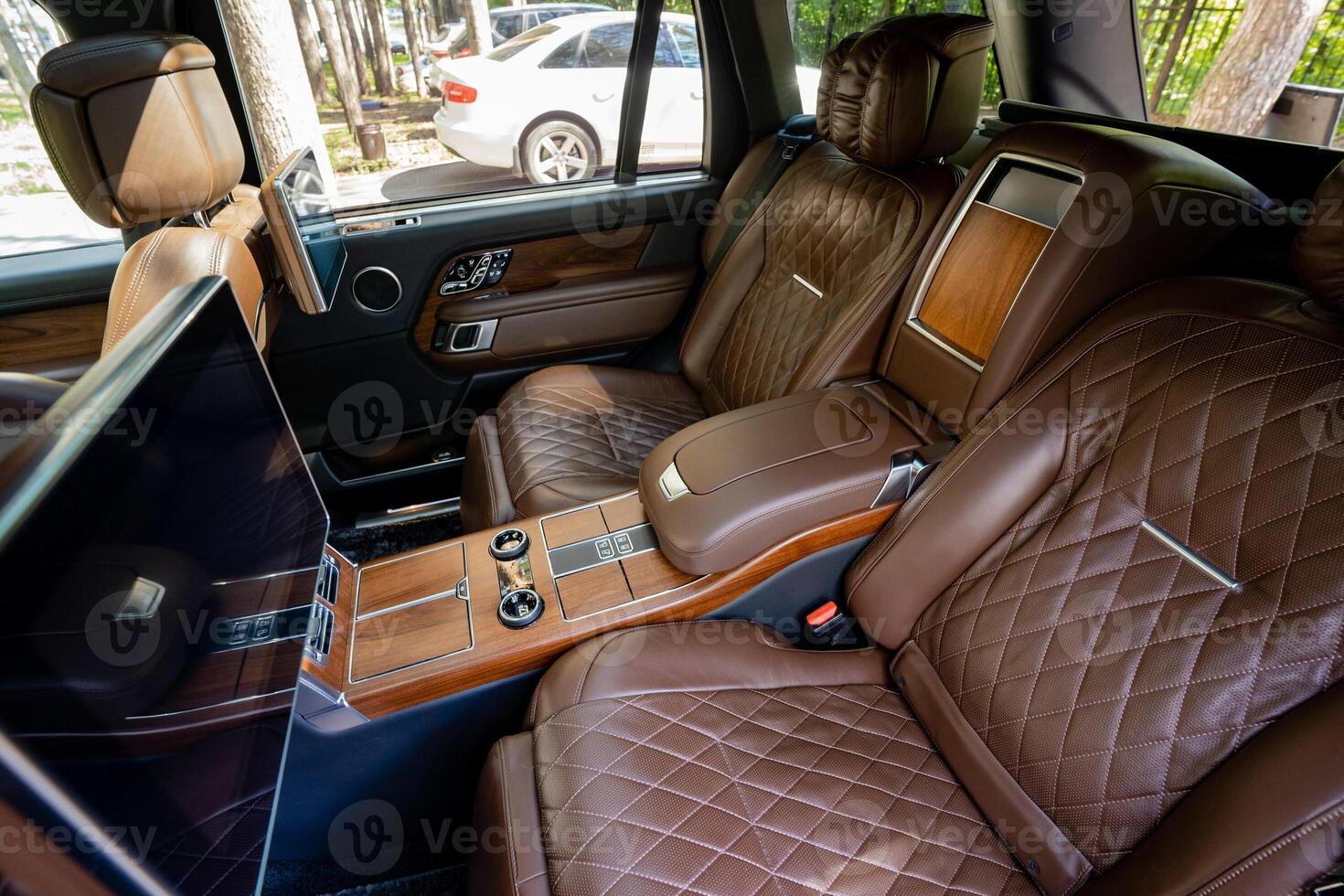 The luxurious brown leather interior of a highend SUV features an array of stylish design elements that elevate the overall ambiance and create an exclusive, sophisticated environment for travel photo