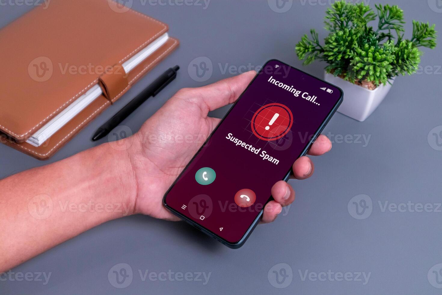 Spammer incoming call concept. Hand holding smartphone with incoming call from unknown caller on phone screen. photo