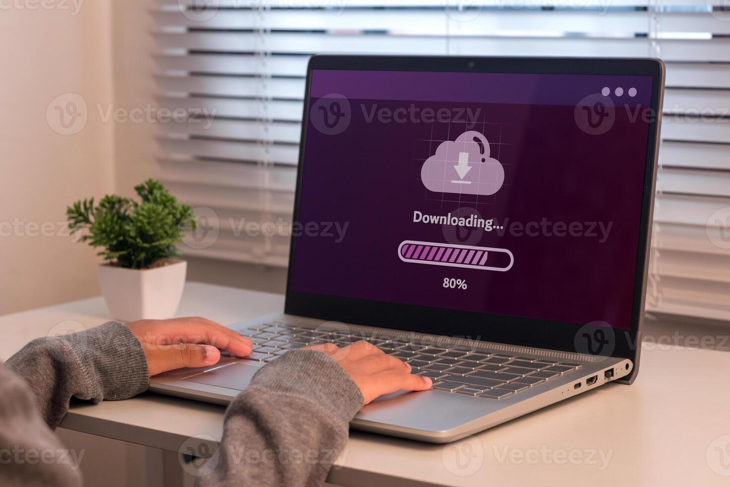 A young girl using laptop to download media or update software. Downloading process bar on laptop screen. photo