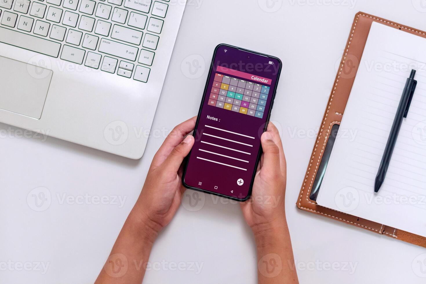 Hands holding a smartphone with calendar app on screen to check schedule, reminder or appointment photo