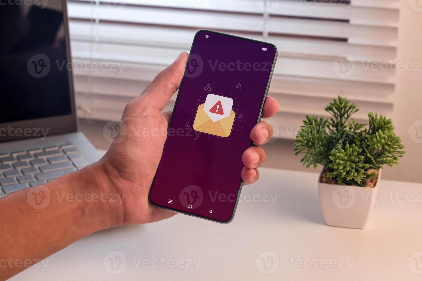 Email or message notification with warning symbol. Man holding a smartphone with email or message spam notification. photo