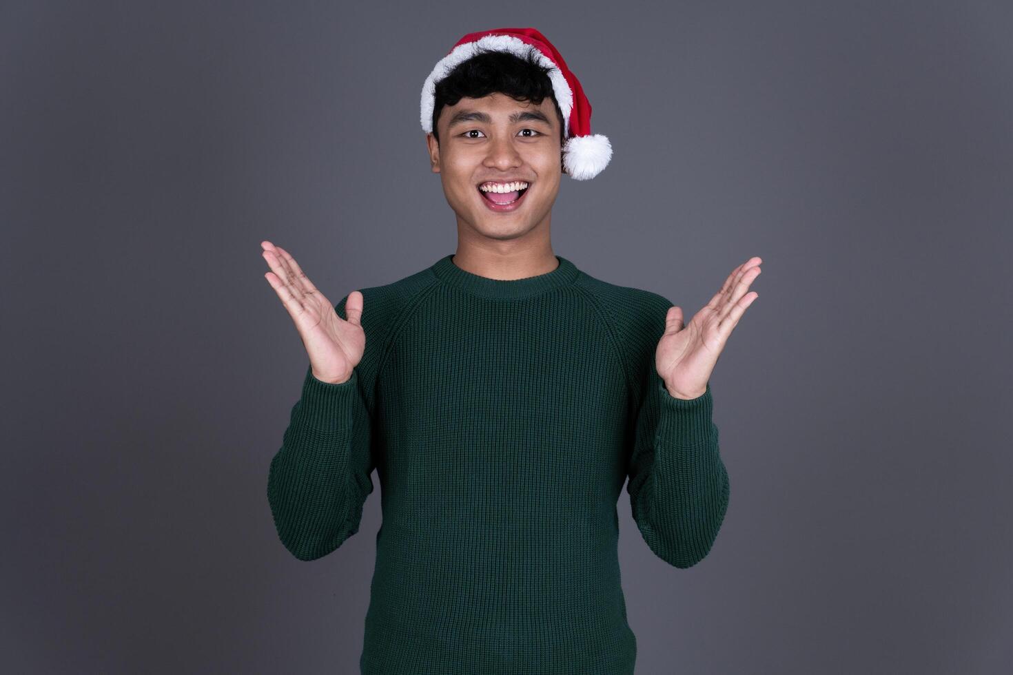 Portrait Excited Young Asian Man Wearing Santa Hat, Christmas Holiday Concept photo