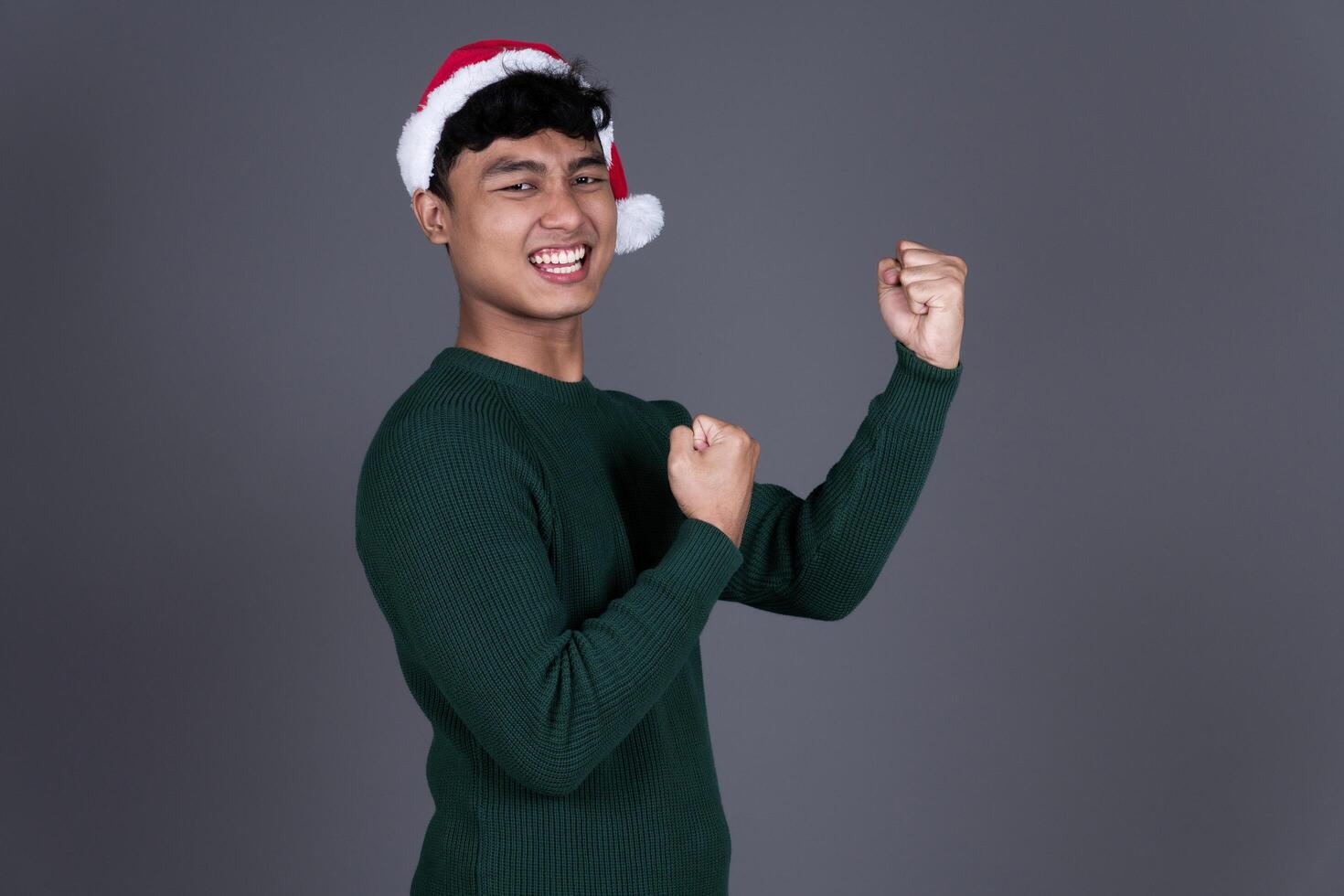 Portrait Very Excited Young Asian Man Wearing Santa Hat, Christmas Holiday Concept photo