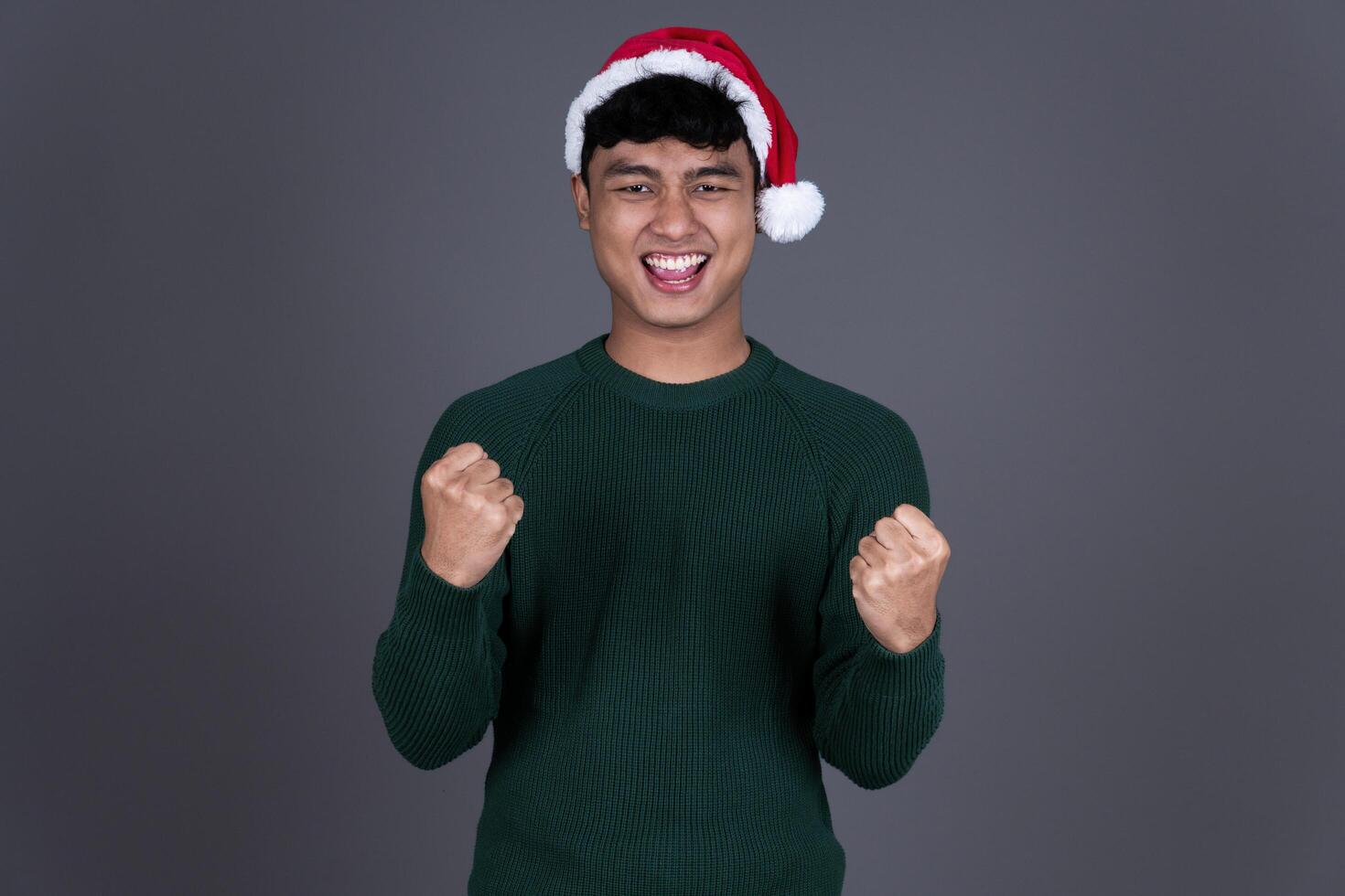 Portrait Excited Young Asian Man Wearing Santa Hat, Christmas Holiday Concept Background photo