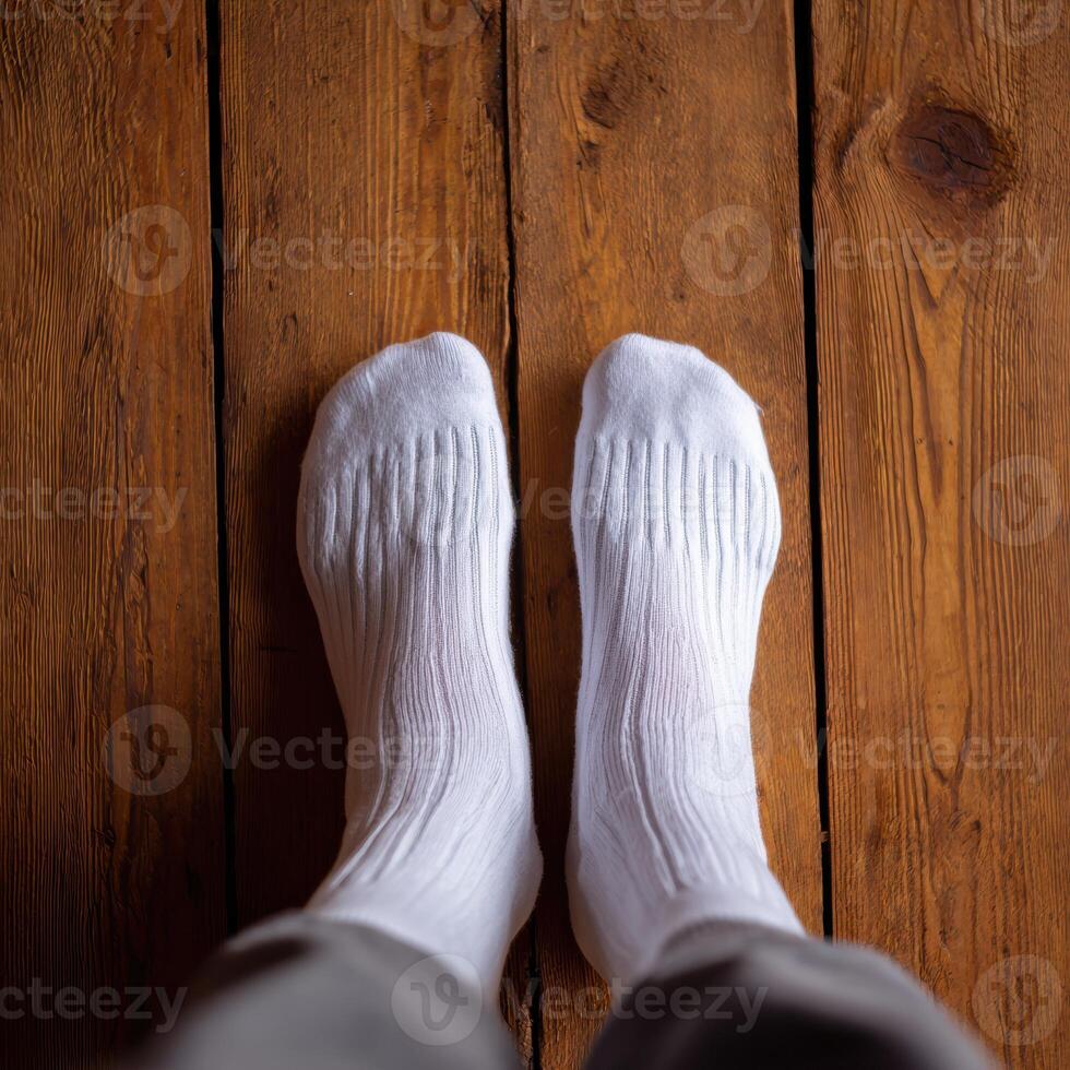 A person wearing white socks standing on a wooden floor photo