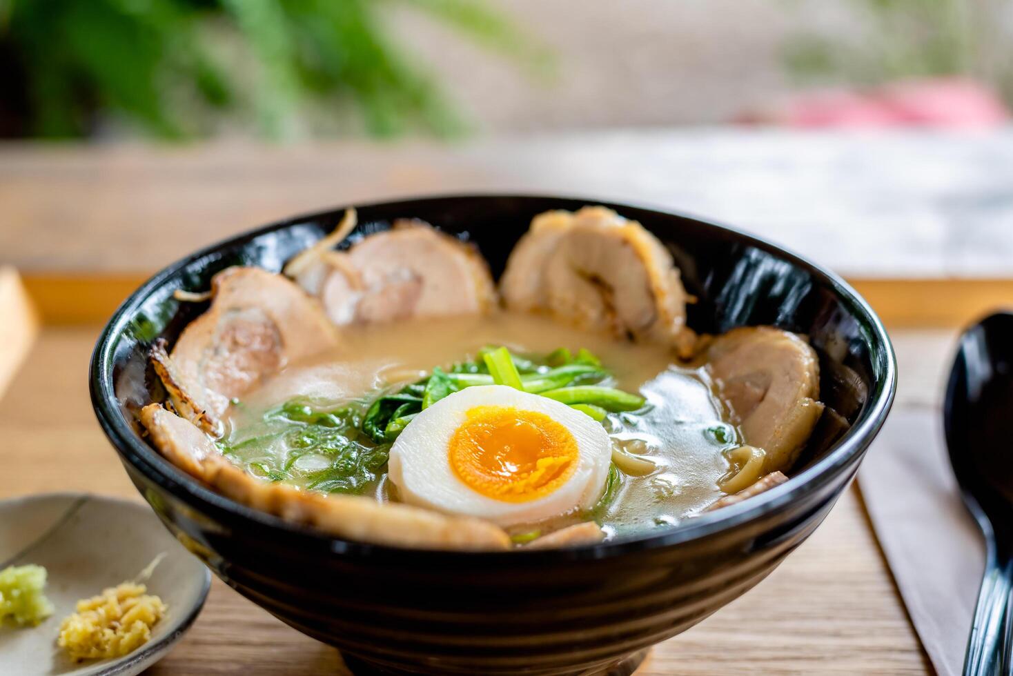 Japanese noodle soup ramen with egg and pork in black ramen bowl for asian food concept. photo