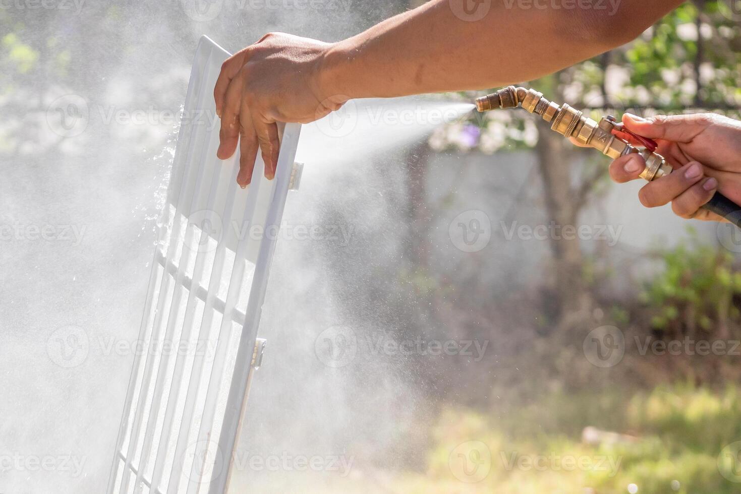 A person is spraying water on a grill photo