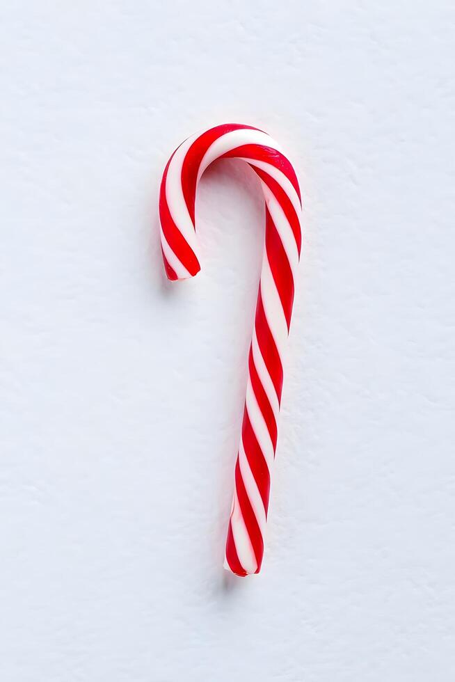Red and White Candy Cane on White Background photo