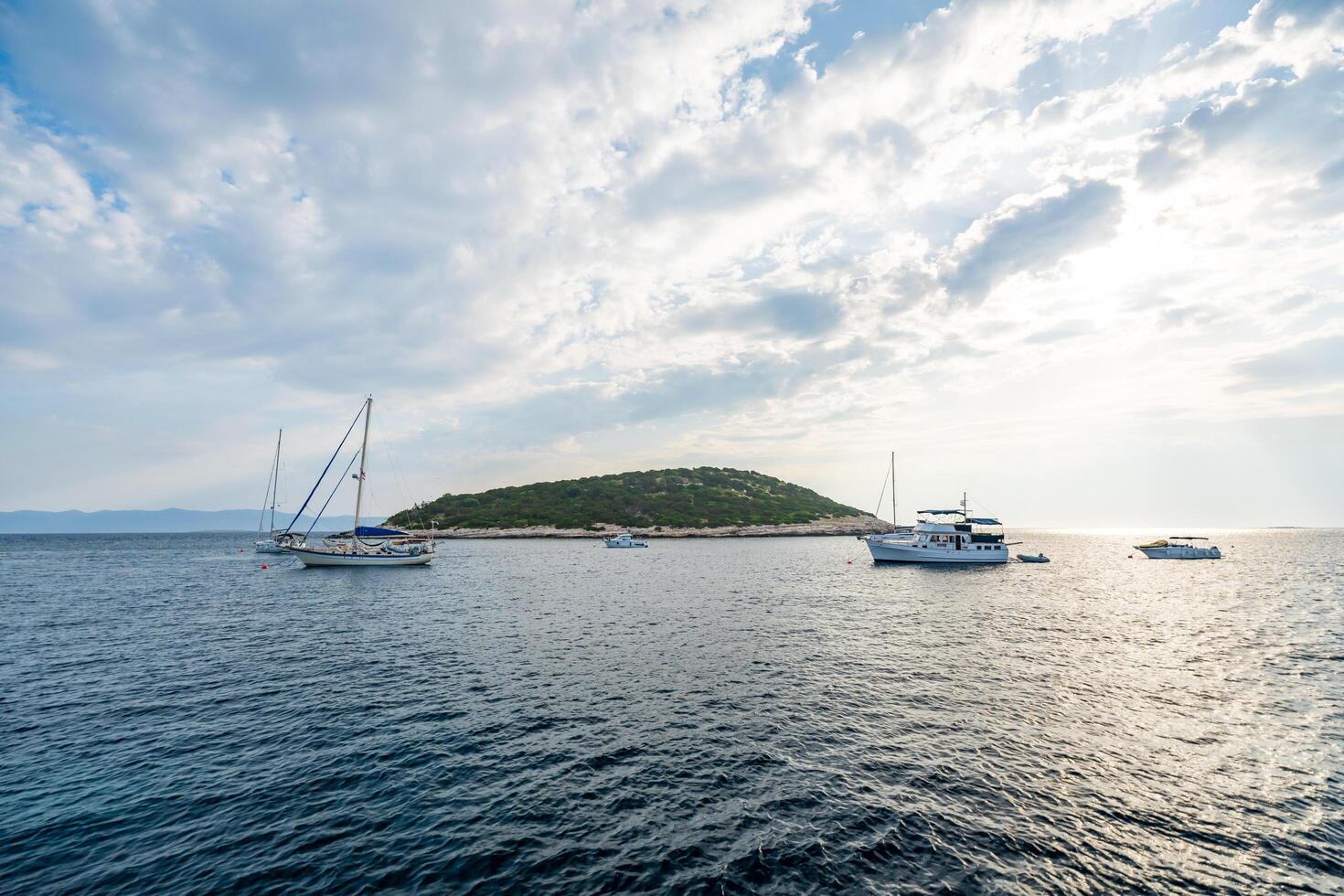 Lastovo, Croatia - June 14, 2025. Sailing yachts anchored near uninhabited islands in Croatia, captured from the bow. Peaceful summer stopover and maritime leisure in a remote coastal area. photo