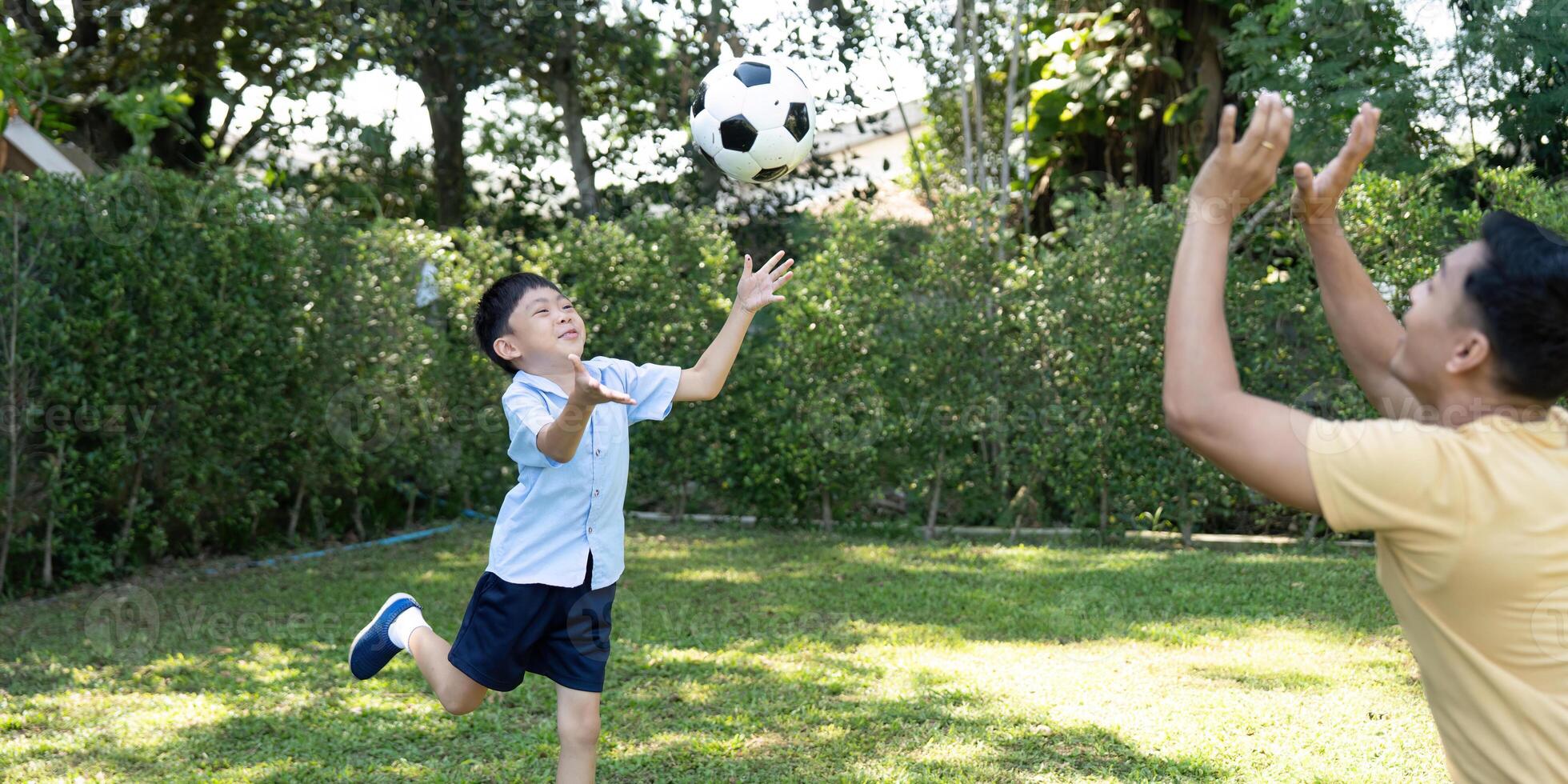 Child Throwing Soccer Ball. Joyful Playtime with Parent photo