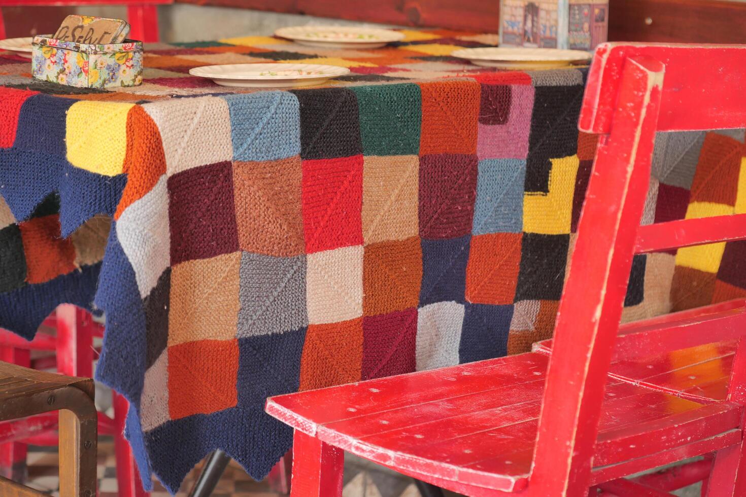 Colorful table setting with knitted blanket and chairs photo