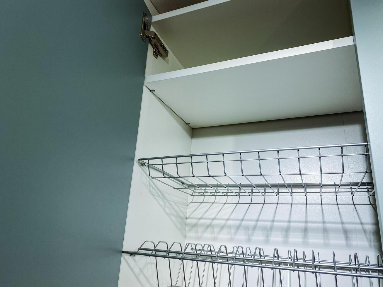 This image showcases a detailed closeup view of a wire rack that is located inside a cabinet, emphasizing its structure and utility in organizing household items effectively photo