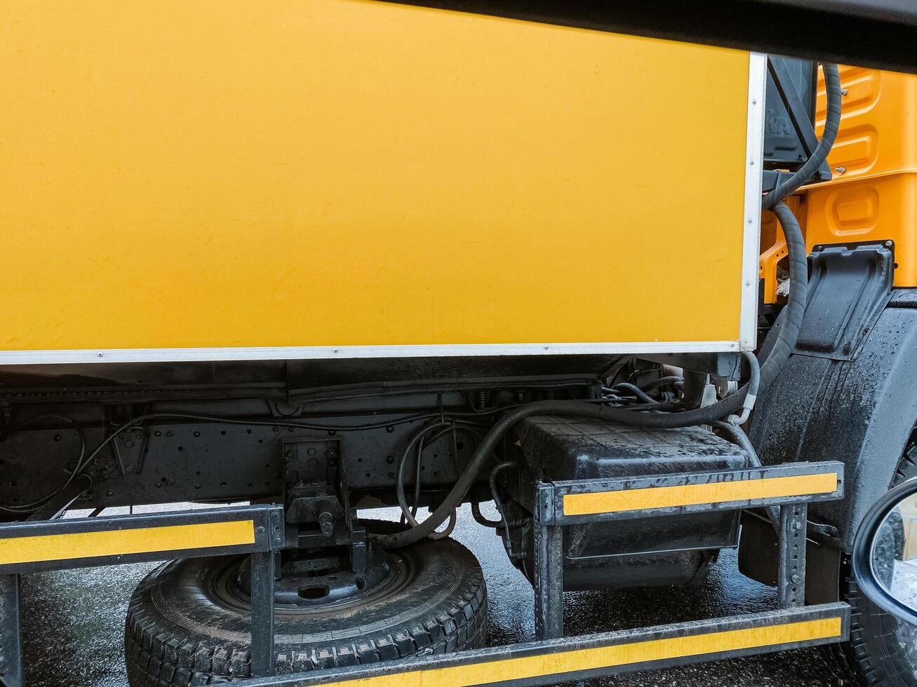 This is an intricate closeup view that showcases the essential components of a yellow trucks underbody and suspension system, highlighting the intricate engineering involved in its design photo