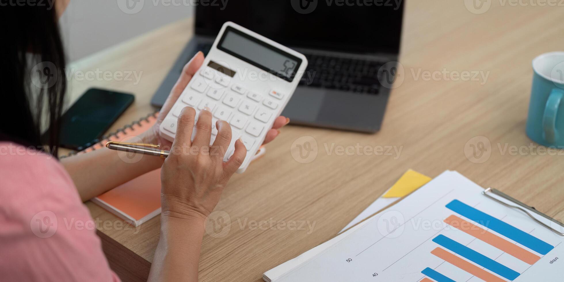 Working from Home. Woman calculating finances with a calculator photo