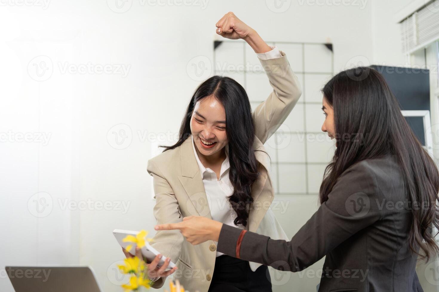 Excited Businesswomen. Two professionals celebrating success with a smartphone in a modern office. photo
