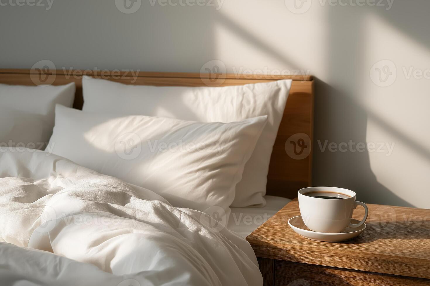 Minimalist bedroom interior with white bedding and soft morning light. A cup of coffee on the nightstand adds a cozy touch to the peaceful space. photo