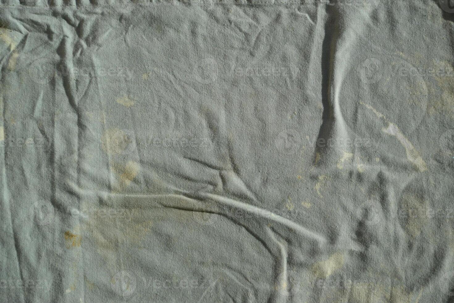 Texture of an old dirty ragged cloth with brown stains. Dirty fabric photo